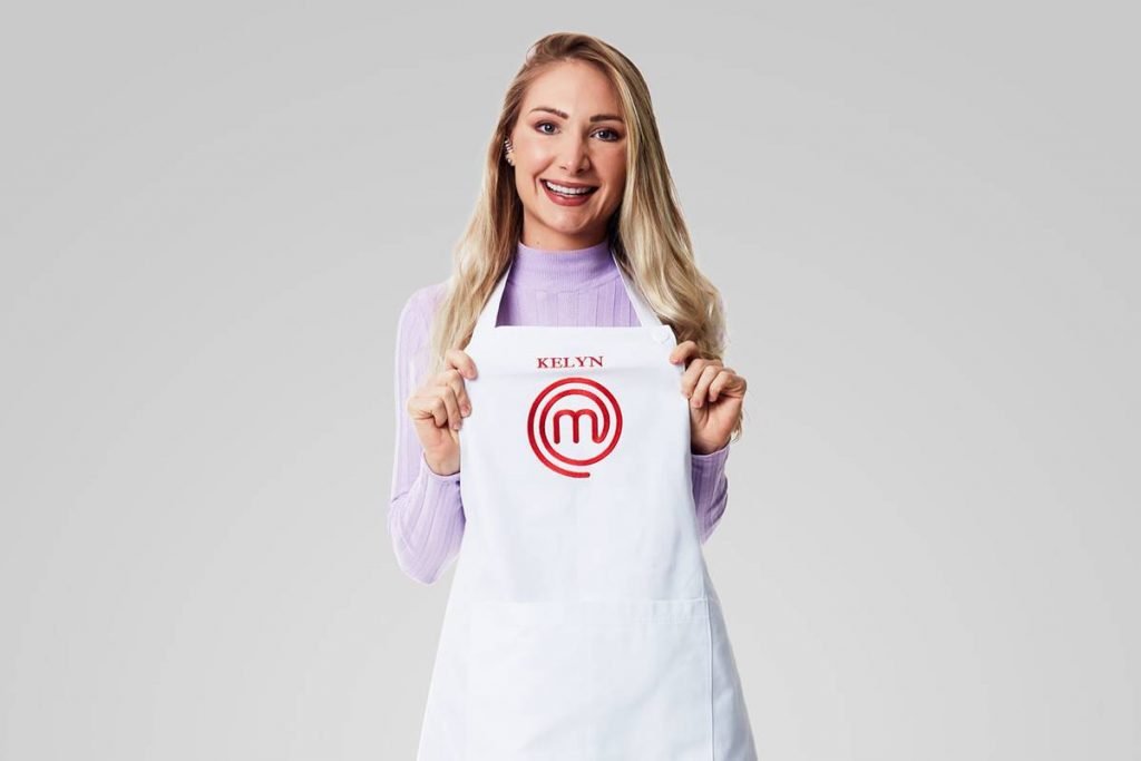 Mulher sorri segurando avental do masterchef