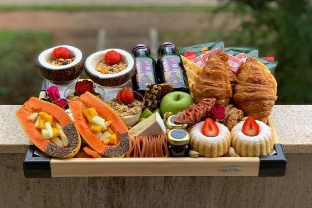 Platter com frutas, pães, sucos e geleias
