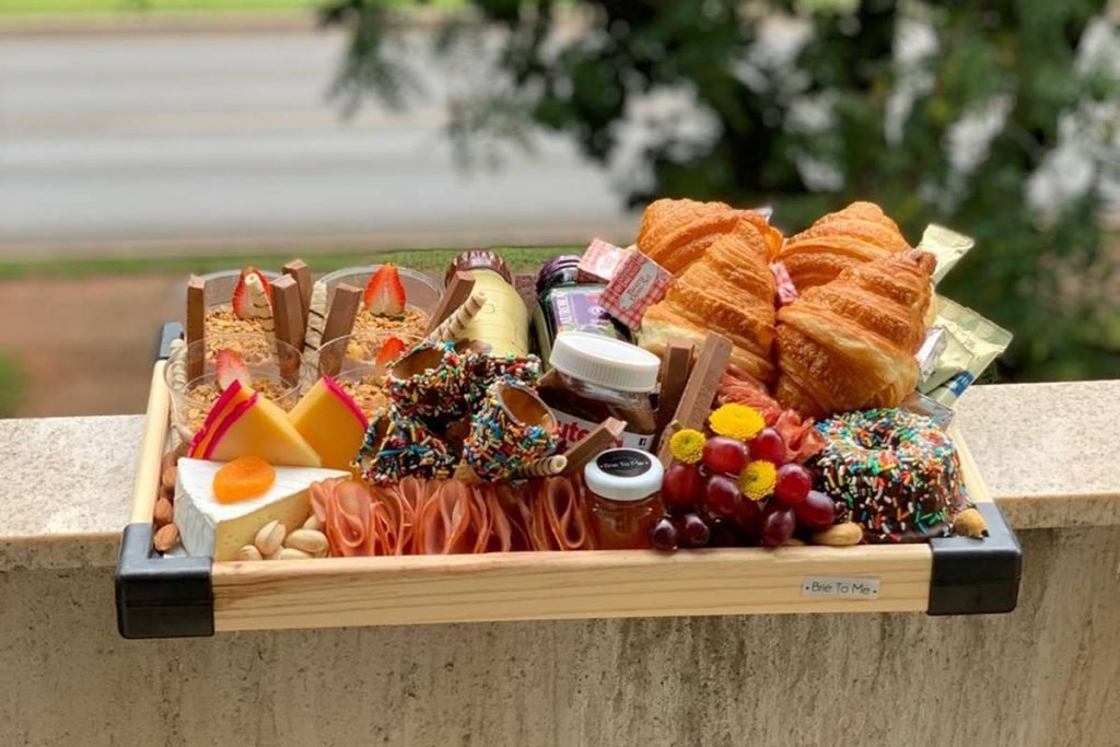 Platter com frios, pães, frutas e geleias