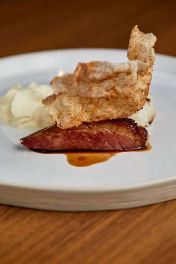 Prato com picanha de porco, espuma de tucupi e arroz de coco
