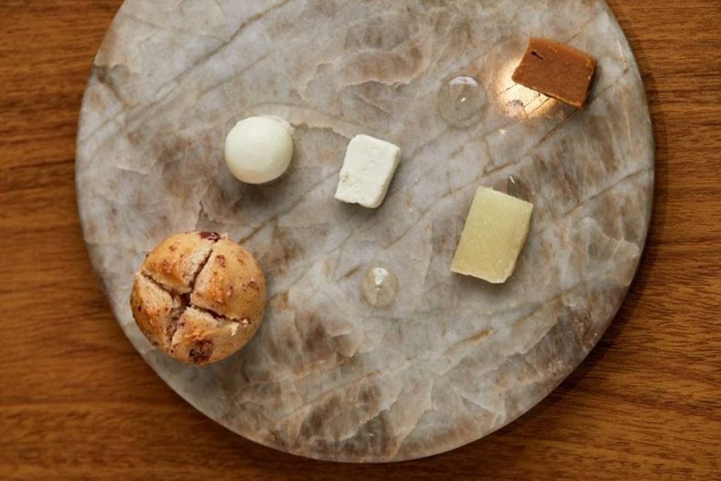 Prato redondo com pão e pedaços de queijo