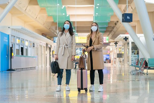 mulheres em aeroporto de máscara