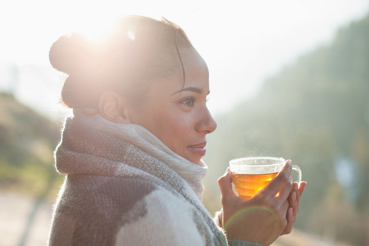 mulher bebendo chá no frio