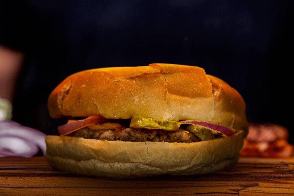 Hambúrguer do tipo smash com cebola e picles