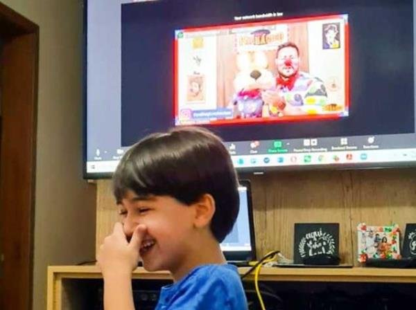 criança rindo do palhaço na tevê