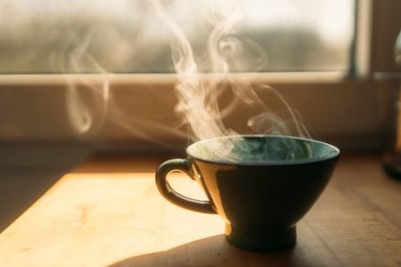 xícara de café ao lado da janela