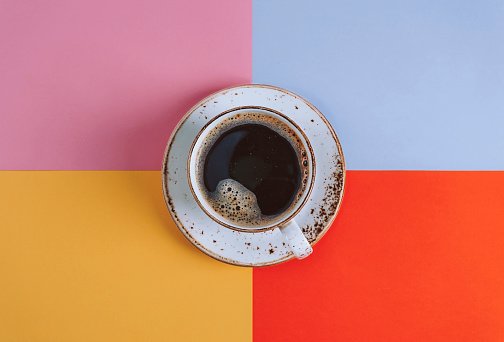 Fotografia colorida. Xícara de café em fundo colorido