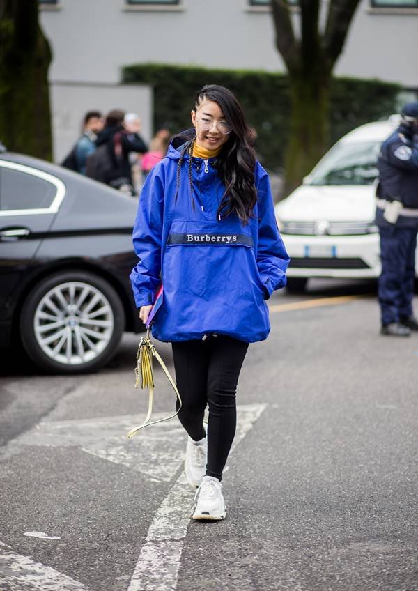 Mulher com jaqueta corta-vento no street style de Milão