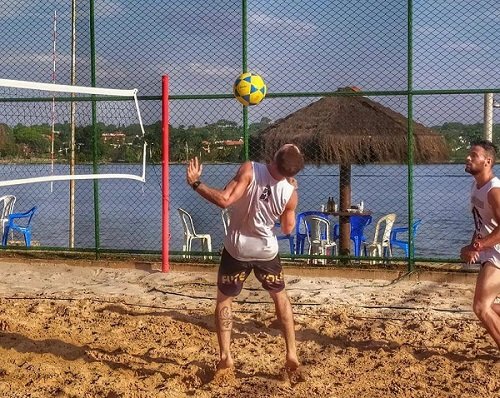 Jovem jogando vôlei de praia. jogos de esporte. jogo de vôlei de praia.  atividades esportivas ao ar livre, férias divertidas.