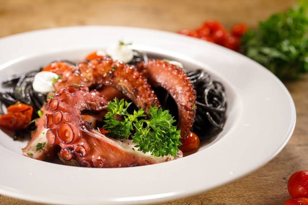 Tentaculos de polvo com macarrão preto