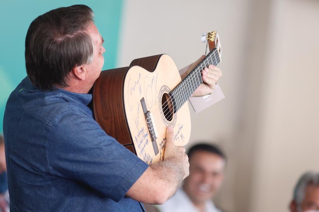 “O povo armado jamais será escravizado”. Fala do presidente depois de recebe um violão de presente e simular estar segurando uma arma com o instrumento