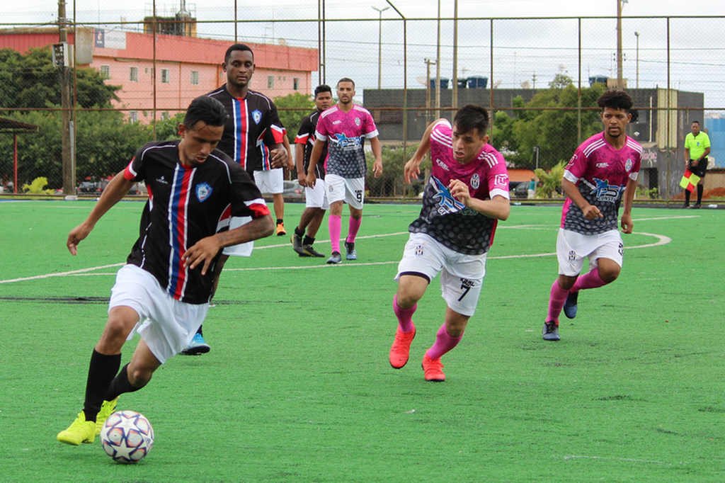 2 jogadores de futebol um deles carrega a bola