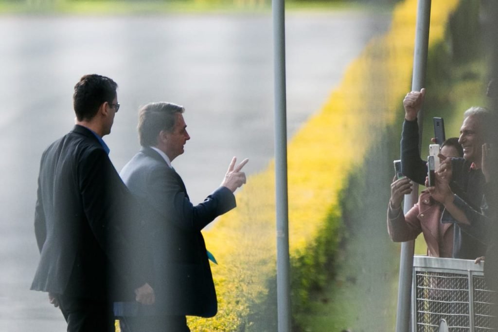 O presidente Jair Bolsonaro cumprimenta apoiadores no Palácio da Alvorada