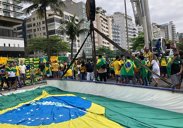 Guindastes ergue uma bandeira do Brasil em manifestação na Praia de Copacabana, no Rio de Janeiro