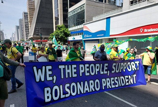 Manifestantes com faixa espalhadas em concentração de ato em SP