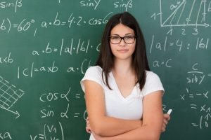 Mulher em frente a um quadro com contas de matemática