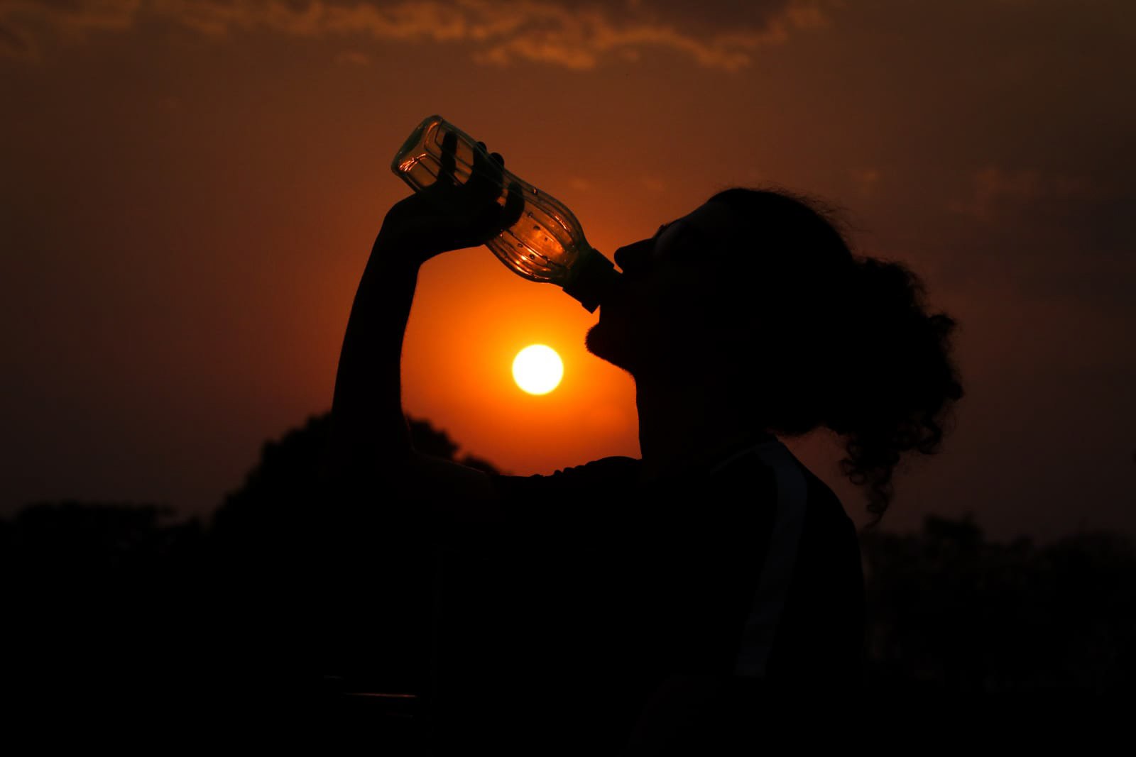 Mulher bebe agua durante calor no DF brasilia
