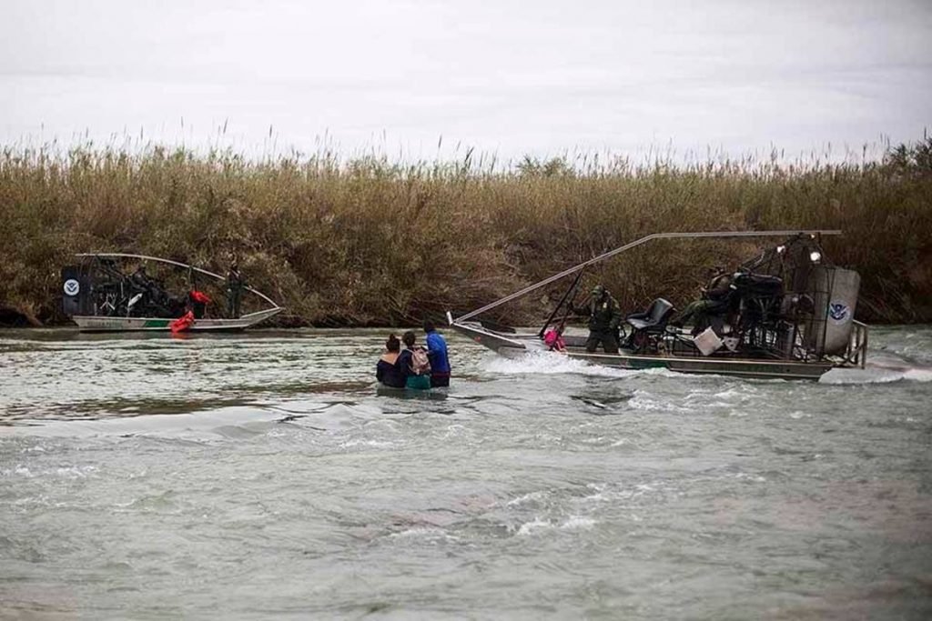 pessoas tentando atravessar rio na fronteira entre México e EUA