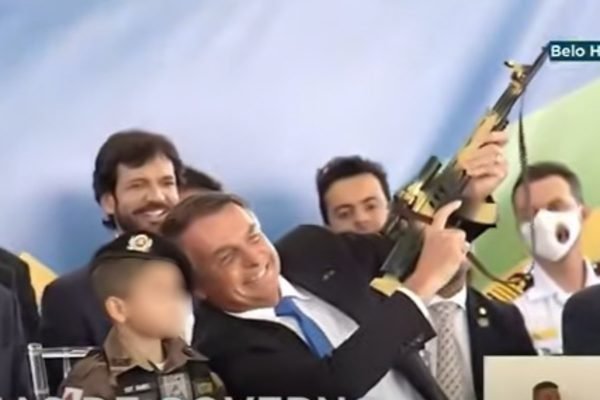 Bolsonaro com arma de brinquedo ao lado de criança vestida de militar