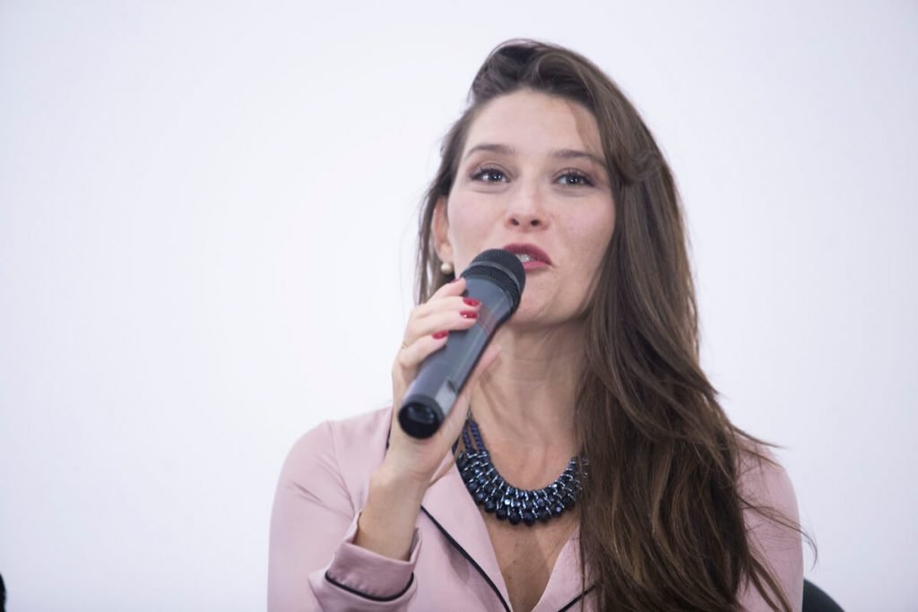 Mulher segura microfone com a mão direita
