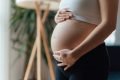 Mulher grávida com as mãos na barriga