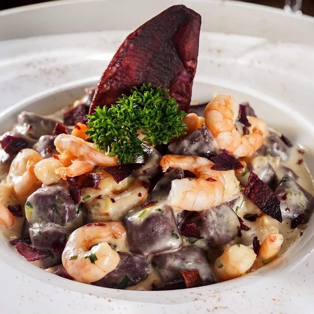 Nhoque de batata roxa e camarão da Ticiana Werner. O prato é feito com camarões grelhados ao molho de leite de coco, pimenta de cheiro e dedo de moça, tomilho, alho poro, salsa e creme de leite fresco