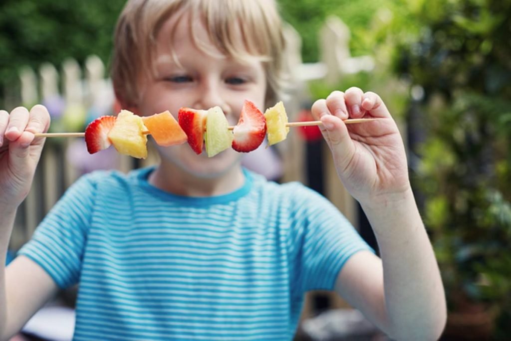 Criança comendo fruta