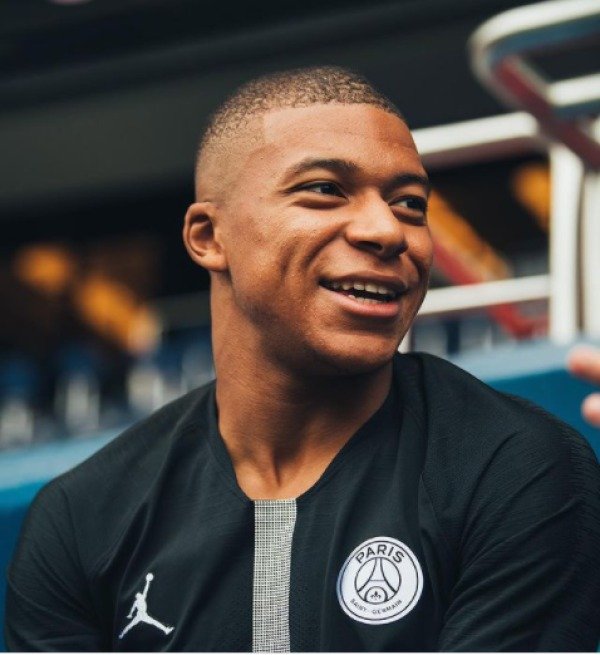 Mbappé com uniforme do PSG, com marca de Jordan ao lado do escudo do time