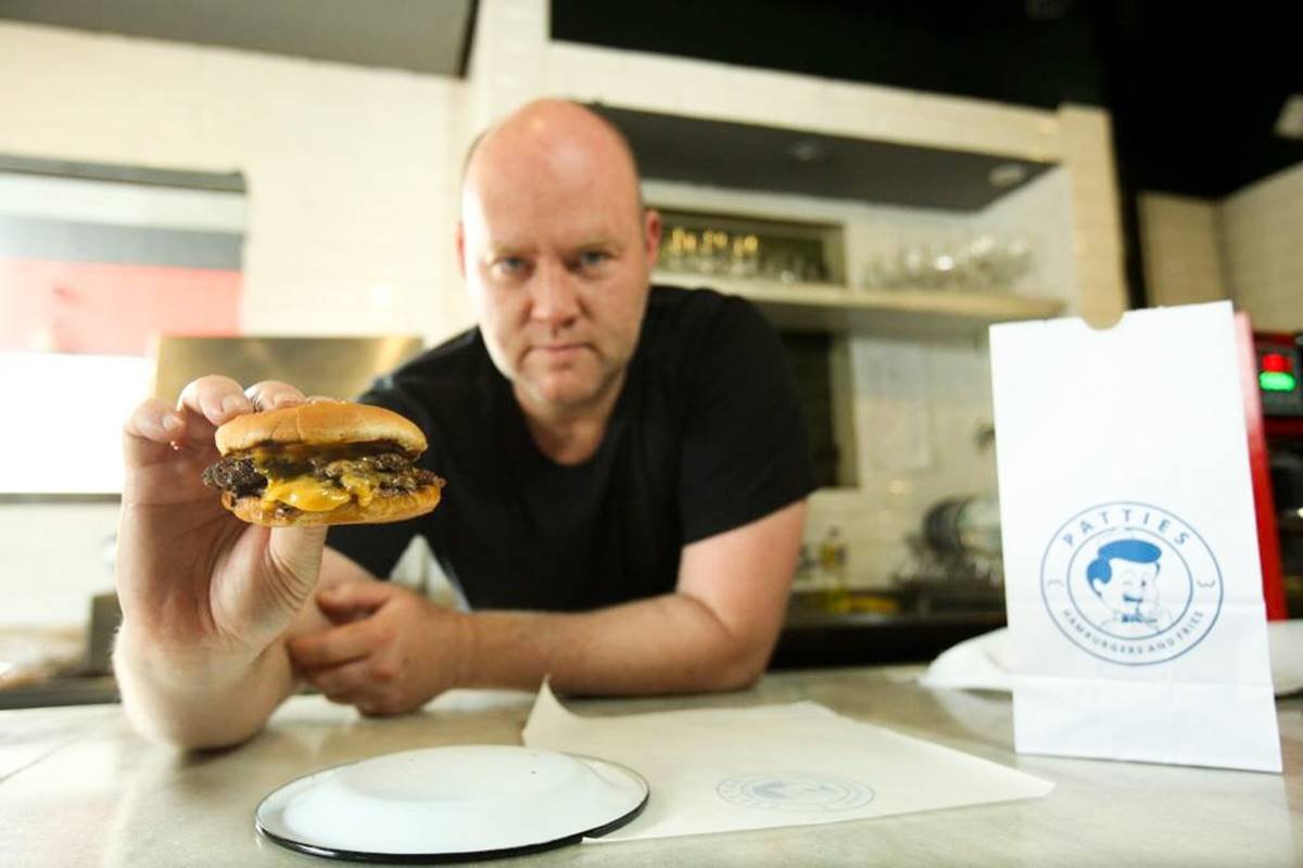 Greg (Greigor Caisley) com hambúrguer na mão