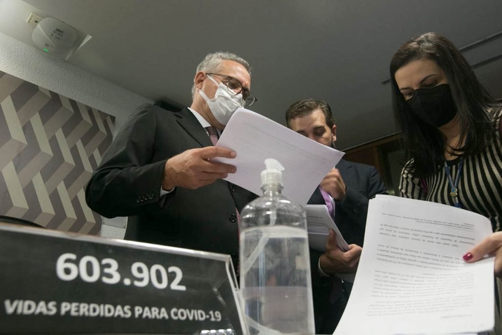 Renan Calheiros conversa com assessores antes da abertura da CPI. Em suas mãos, o relatório da CPI