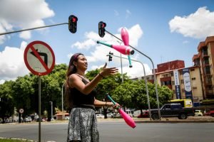 Artista circense joga malabares no semáforo