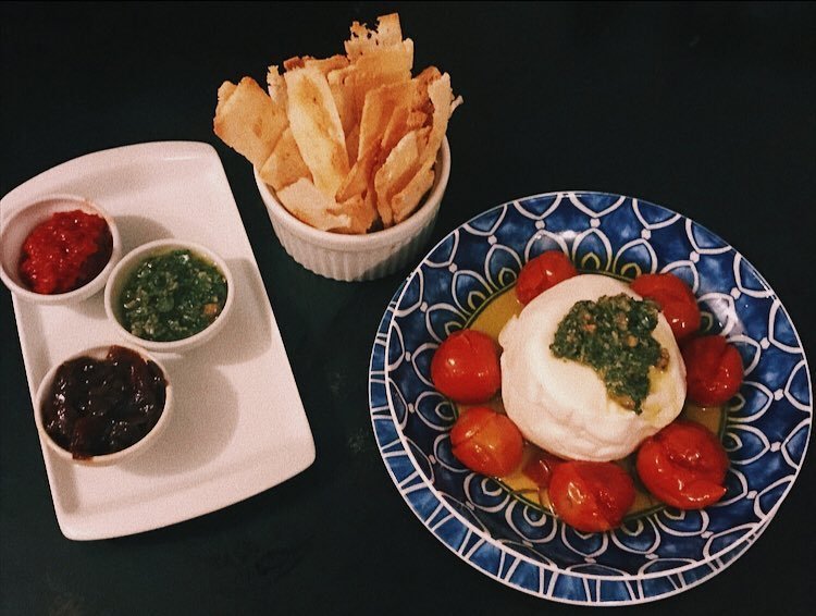 Burrata acompanhada de tomates confit, focaccia tostada, agridoce, sardella e pesto