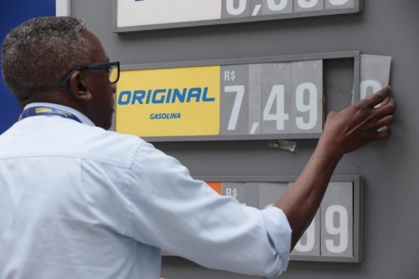 Frentista mudando preço de gasolina em placa