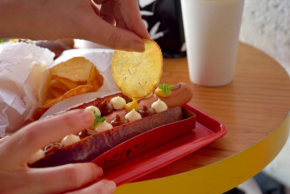 Cachorro quente com molho e acompanhamentos