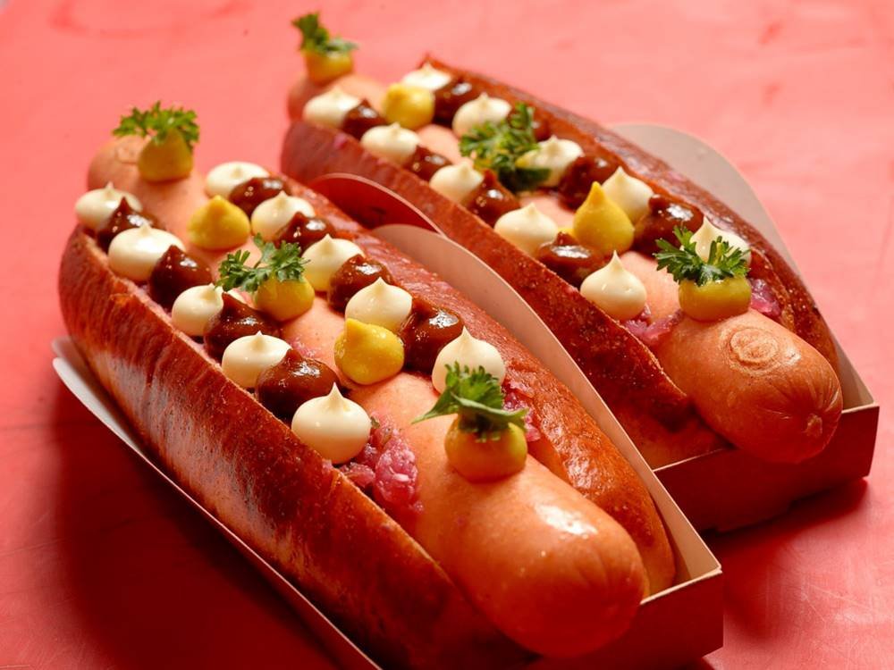 Cachorro quente com molho e acompanhamentos