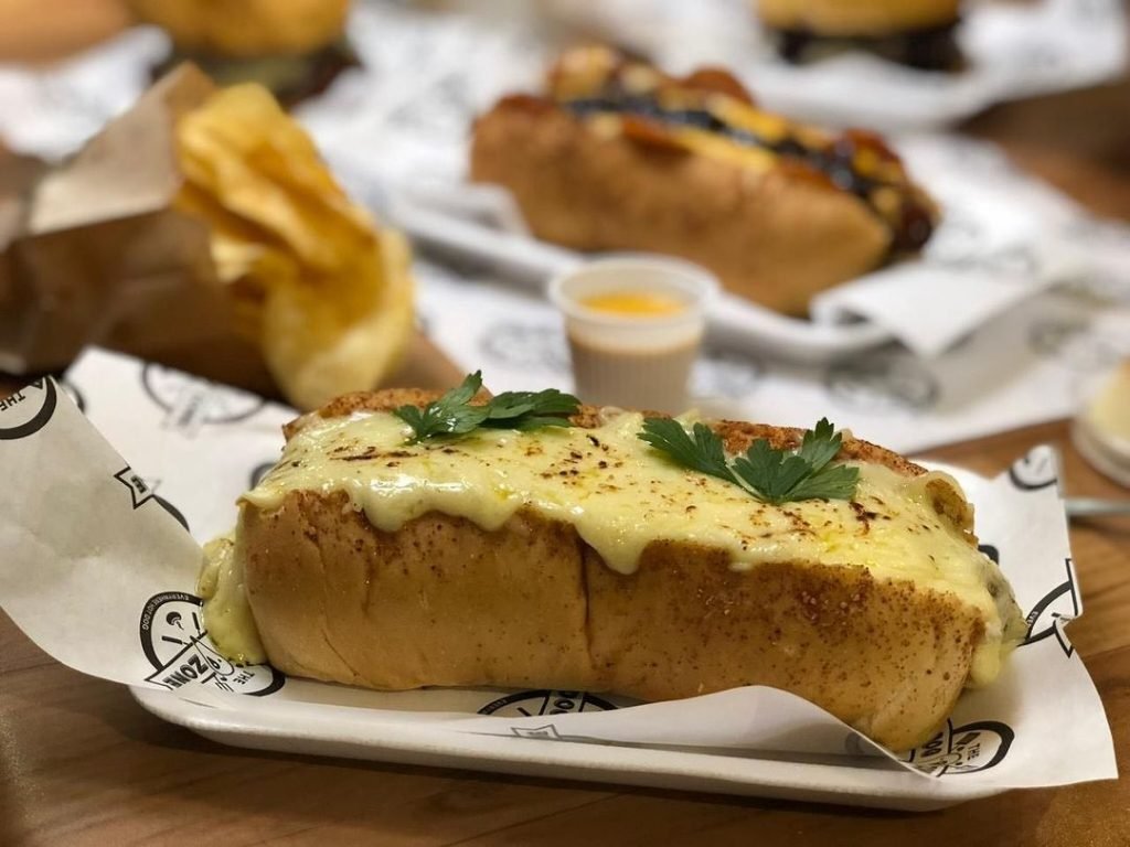 Cachorro quente com molho e acompanhamentos