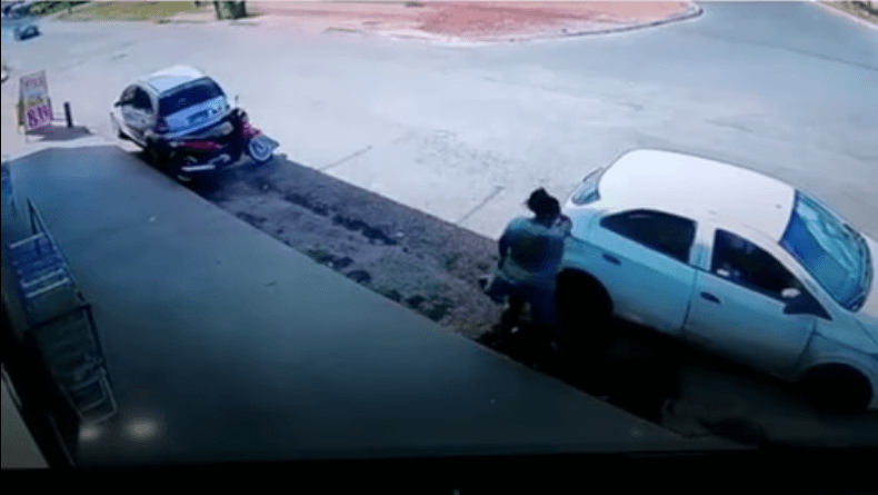 No começo do vídeo, a mulher aparece descendo do banco de trás do veículo, ela fala e gesticula em direção ao motorista