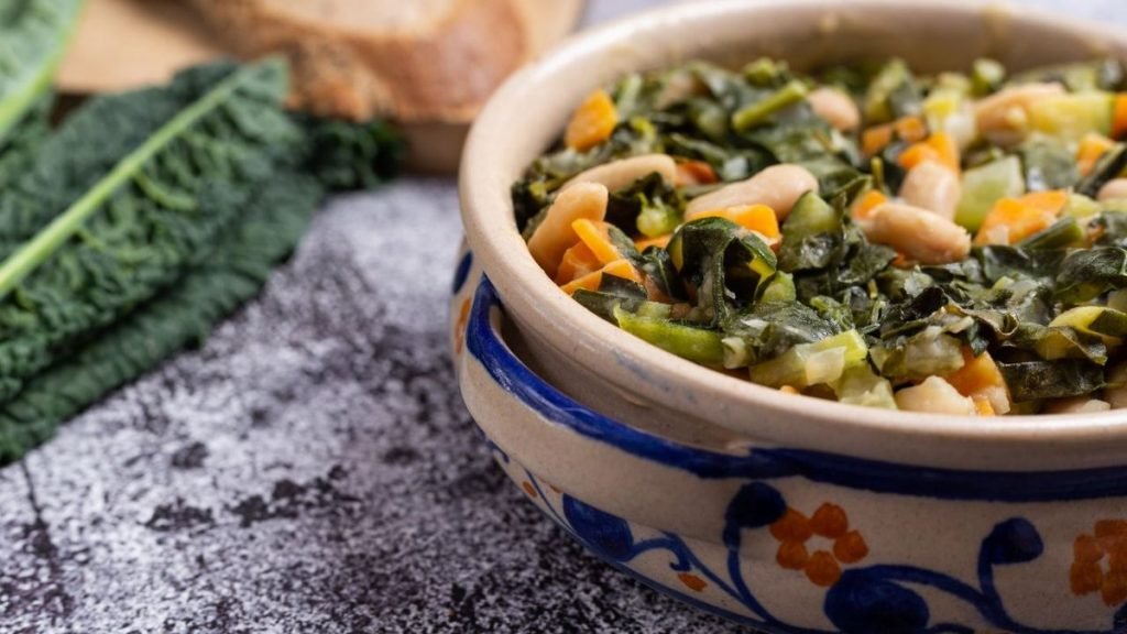 Na imagem, prato de comida com couve verde em cima de uma mesa cinza - Metrópoles