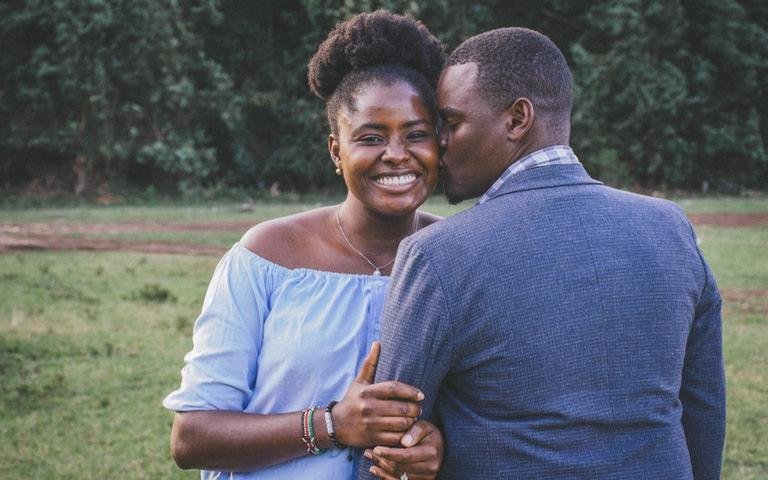 Casal feliz, homem de costas beijando mulher