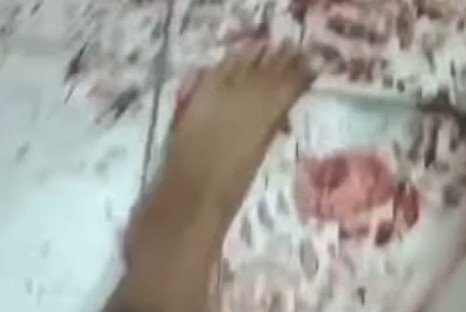 pé estendido acima de chão sujo de sangue