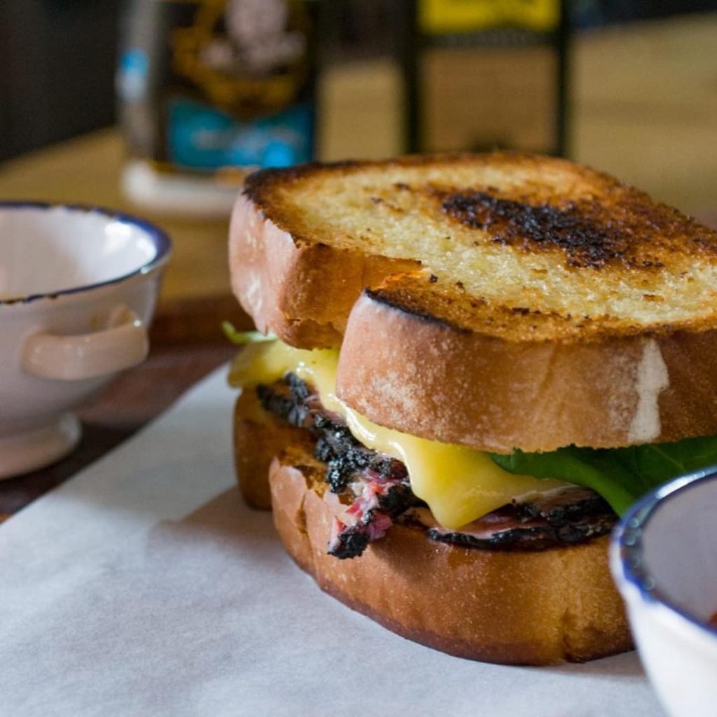 Sanduíche de pastrami, queijo gouda, picles e rúcula, com fritas do Téro Cocina