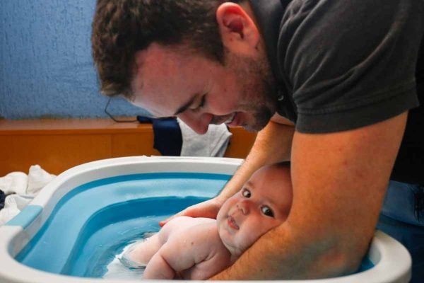 Médico da Marinha e pai solo, Tiago de Oliveira Costa banha filho gestado em barriga solidária