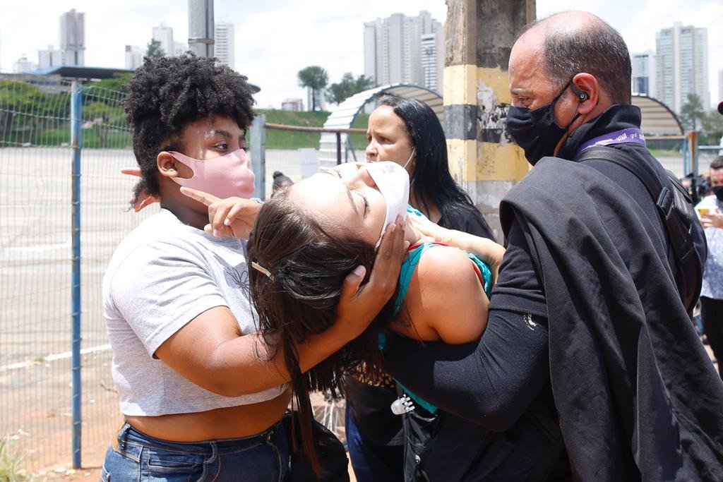 Talita Sena, moradora do setor Nova Vila em Goiânia, desmaia na fila e é carregada pelo cinegrafista Humberto da Rede Globo.
