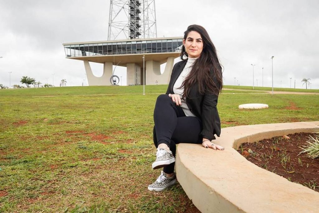 mulher sentada com torre de tv ao fundo