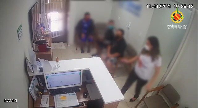 Três pessoas aguardam sentada e mulher caminha por sala