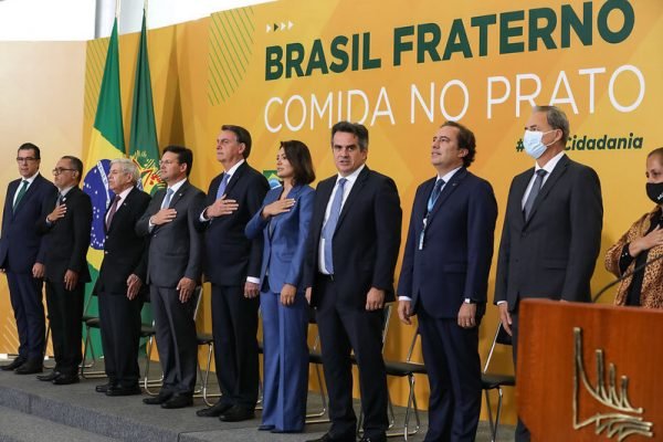 Jair Bolsonaro, Michelle Bolsonaro e ministros durante a execução do hino nacional em lançamento de ação social do governo federal