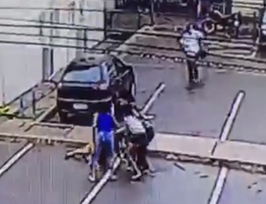 mulher deitada no chão sendo agredida por outras mulheres