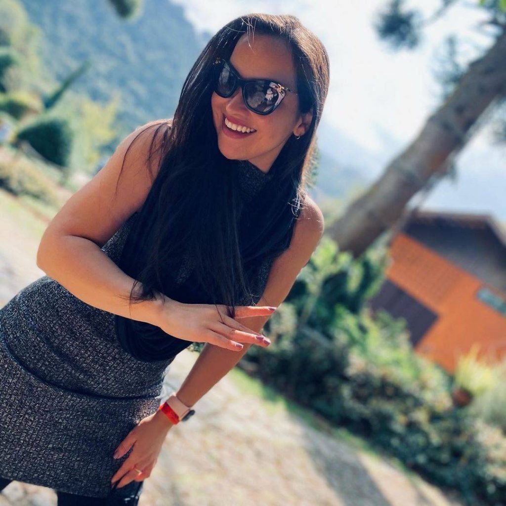 Mulher posa perto de casa