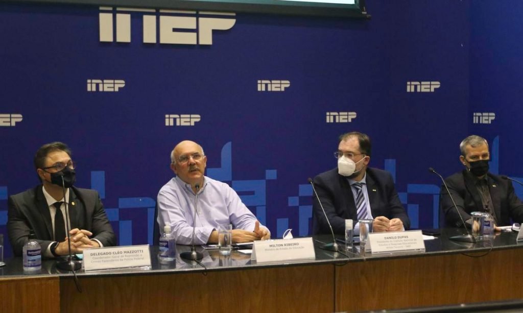 quatro homens dentados atrás de uma mesa. o fundoo é azul com o logotipo do inep