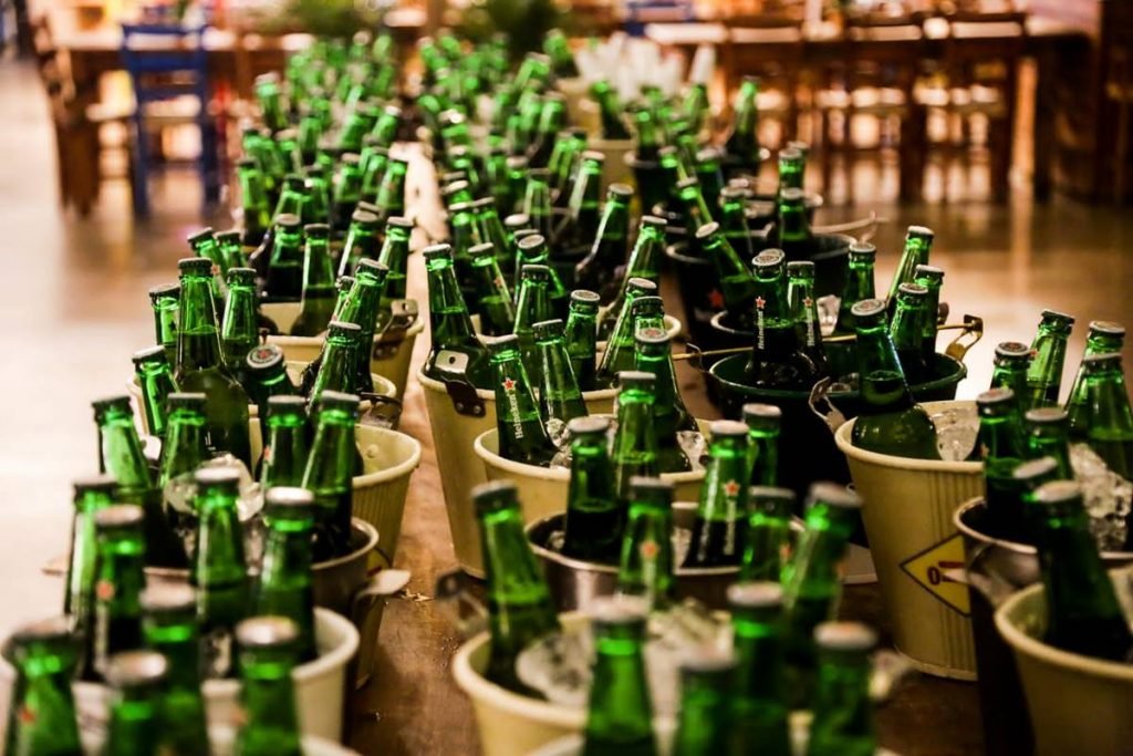 várias garrafas verdes de cerveja em baldes com gelo